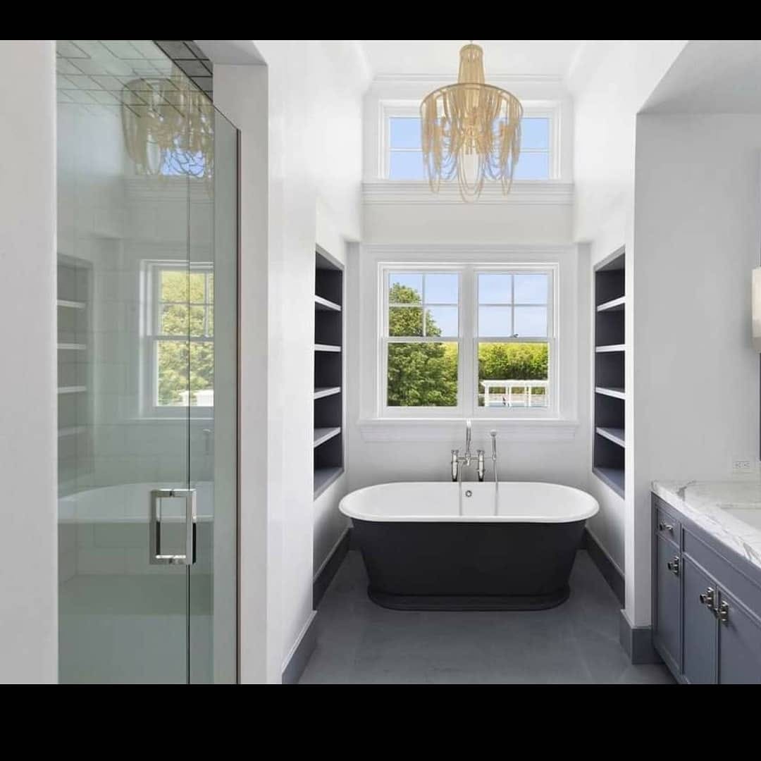 Finished bathroom alcove with crisp white walls and dark built-in shelving