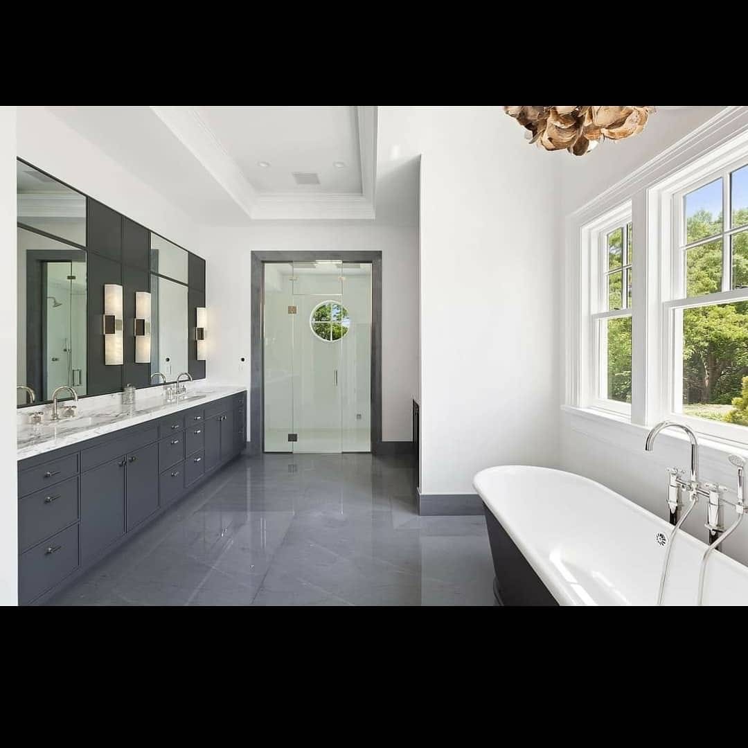 Finished bathroom with white walls, dark cabinetry, and freestanding tub