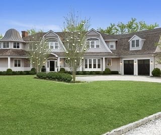 Newly painted home exterior with white trim and a manicured lawn