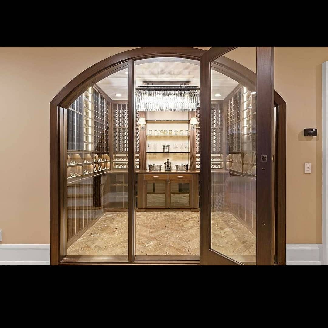 Finished arched wine room with wood trim and detailed millwork