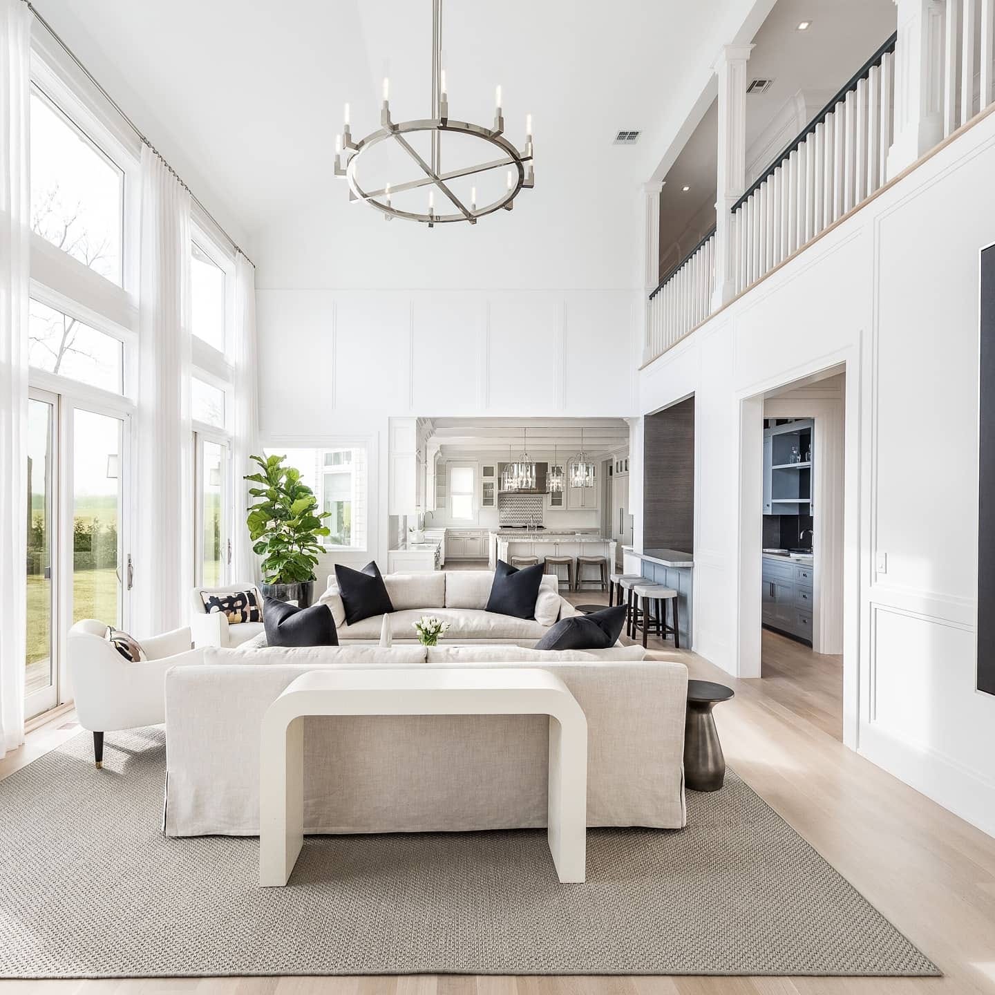 Two-story great room with tall white windows, panel molding, and a coffered ceiling