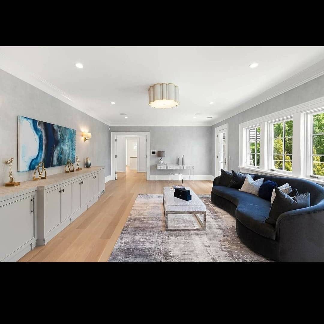 Finished lounge with soft gray walls, white trim, and built-in cabinetry